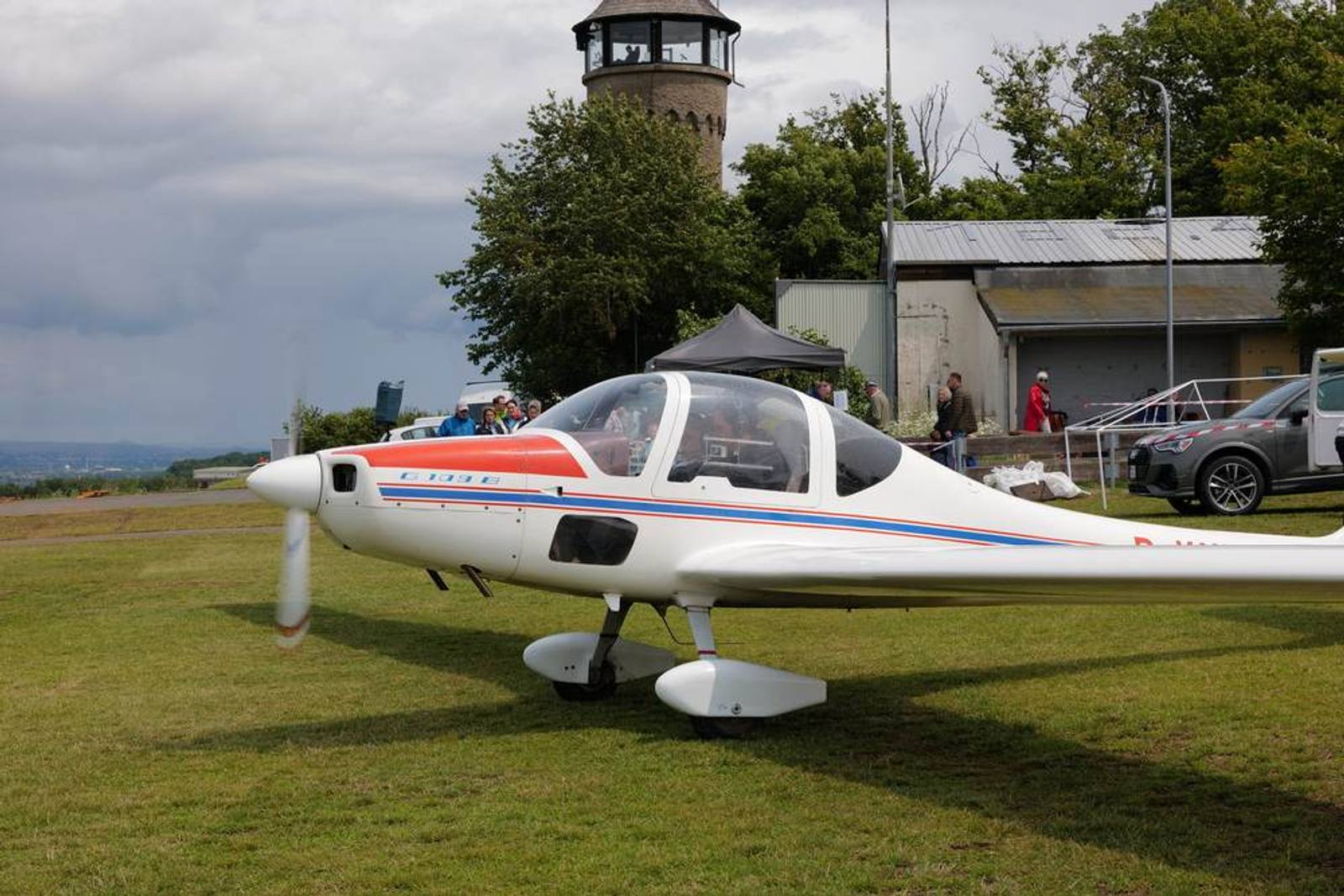 Weiß-rotes Motorflugzeug auf der Graspiste