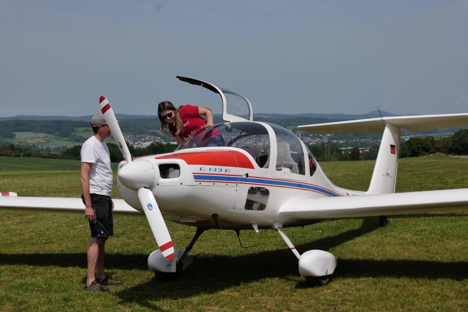 Eine Passagierin steigt in den Motorsegler ein