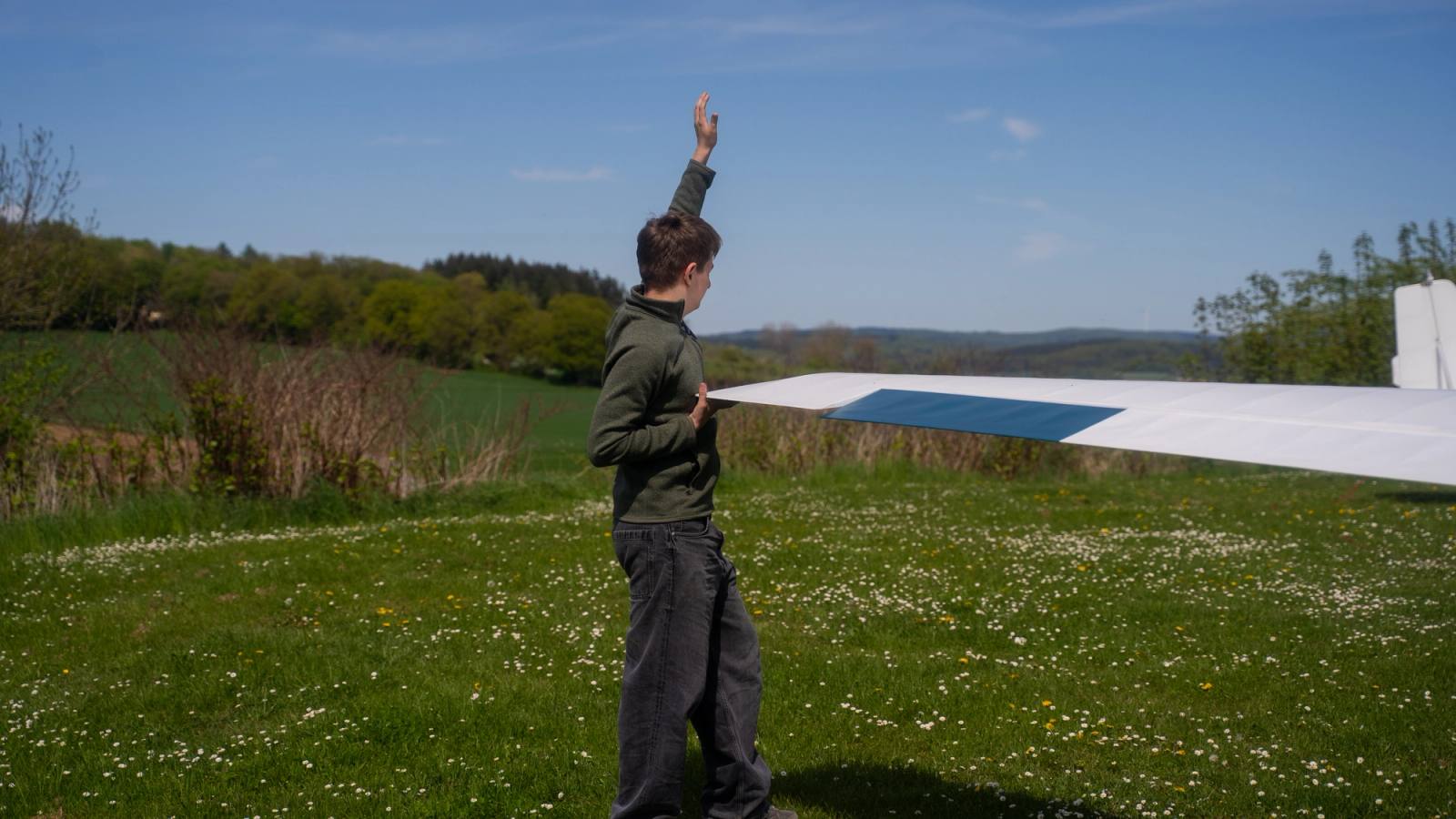 Drei Jugendliche am Propeller des Ultraleichtflugzeugs