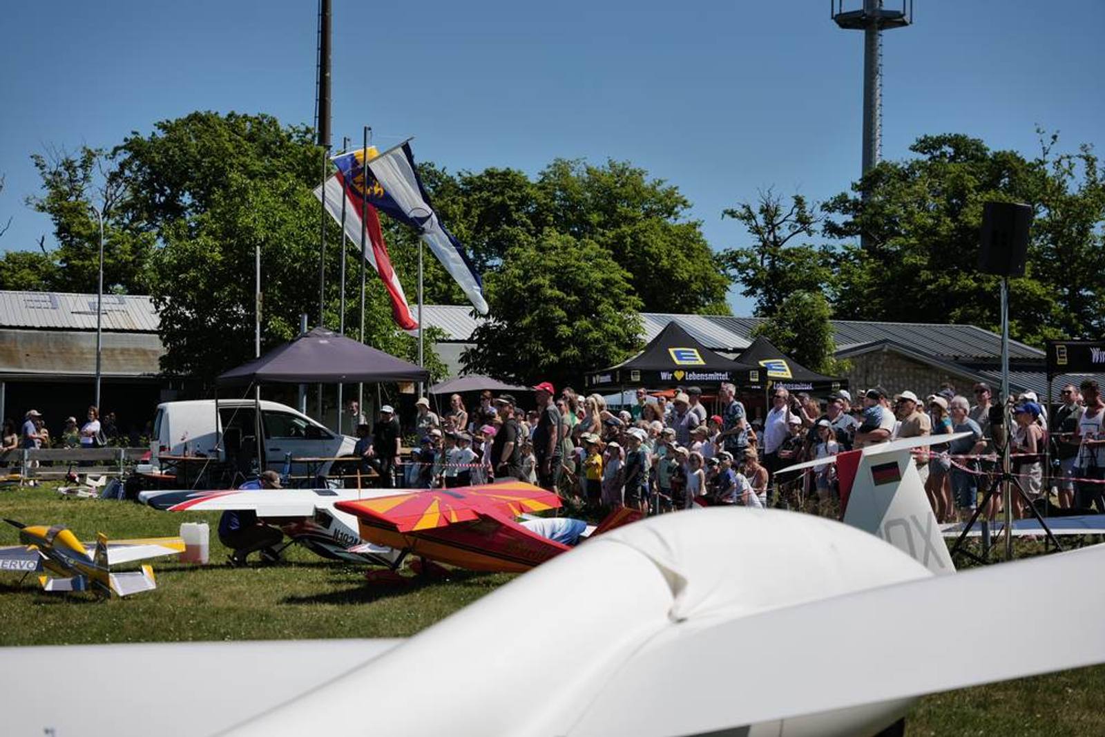 Besucherinnen und Besucher zwischen Flugzeugen und Zelten
