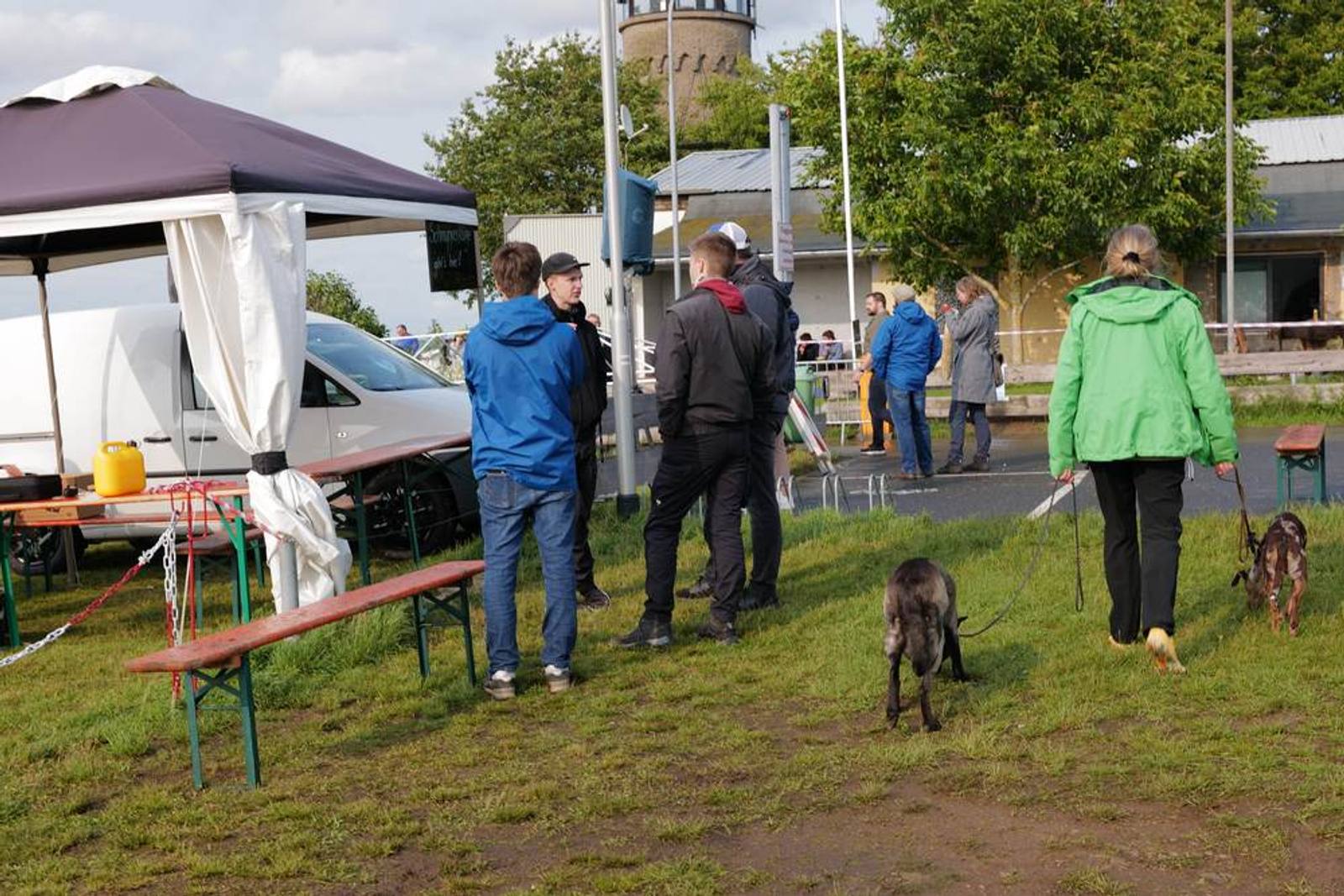 Besucherinnen und Besucher auf der Wiese, ein Hund dabei