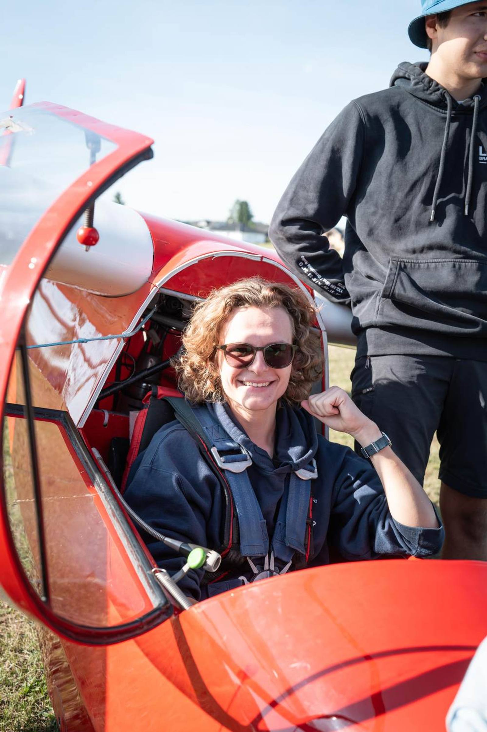 Person im Cockpit eines roten Segelflugzeugs