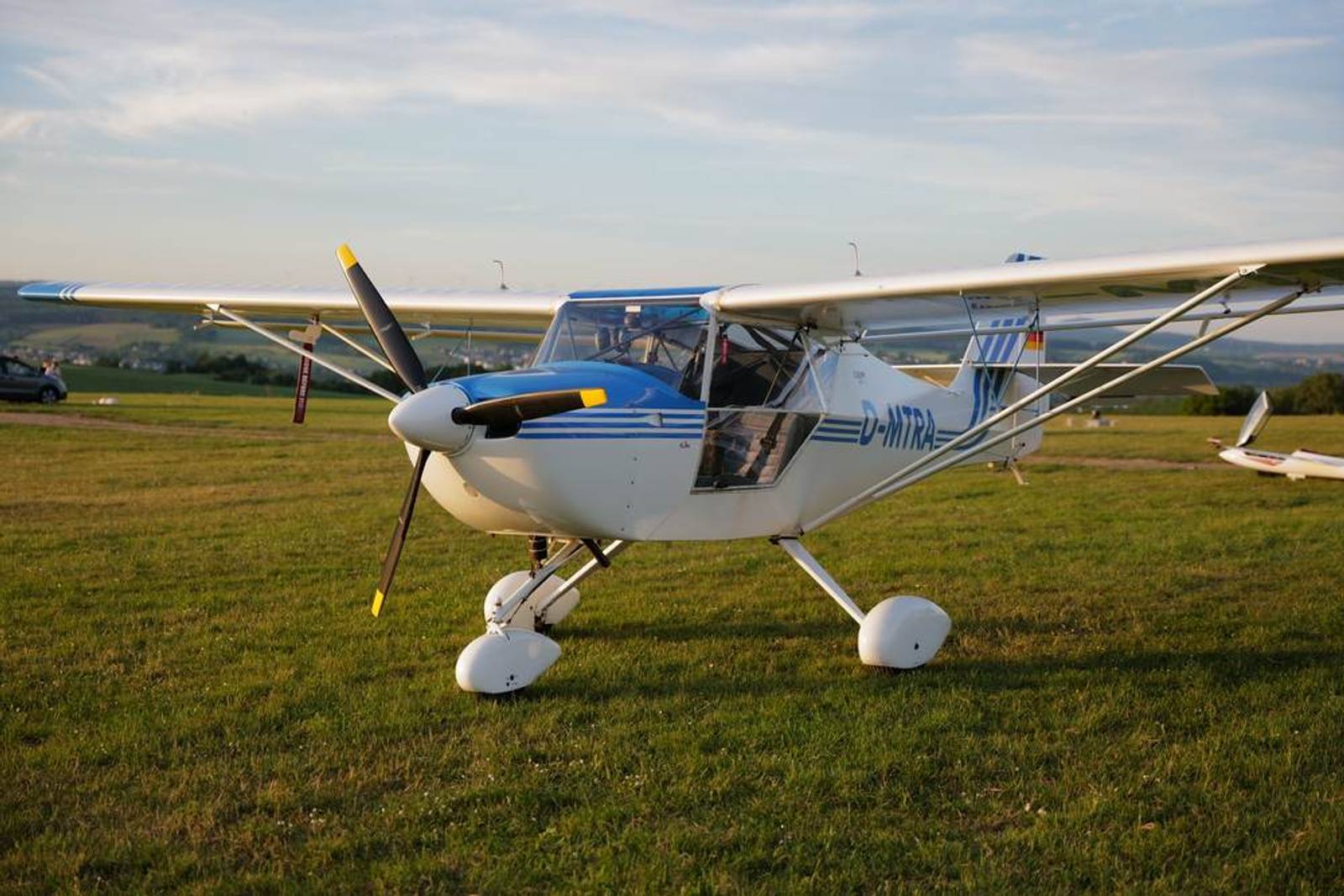 Ultraleichtflugzeug auf der Wiese im Abendlicht