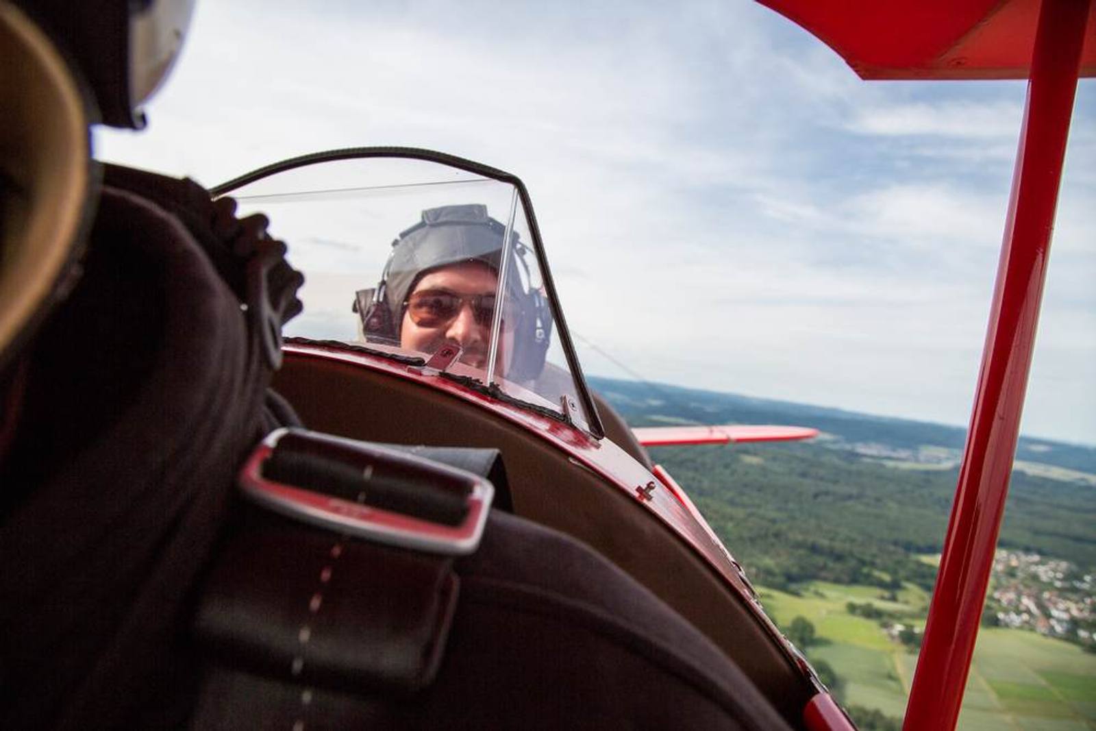 Pilot im offenen Cockpit eines Doppeldeckers