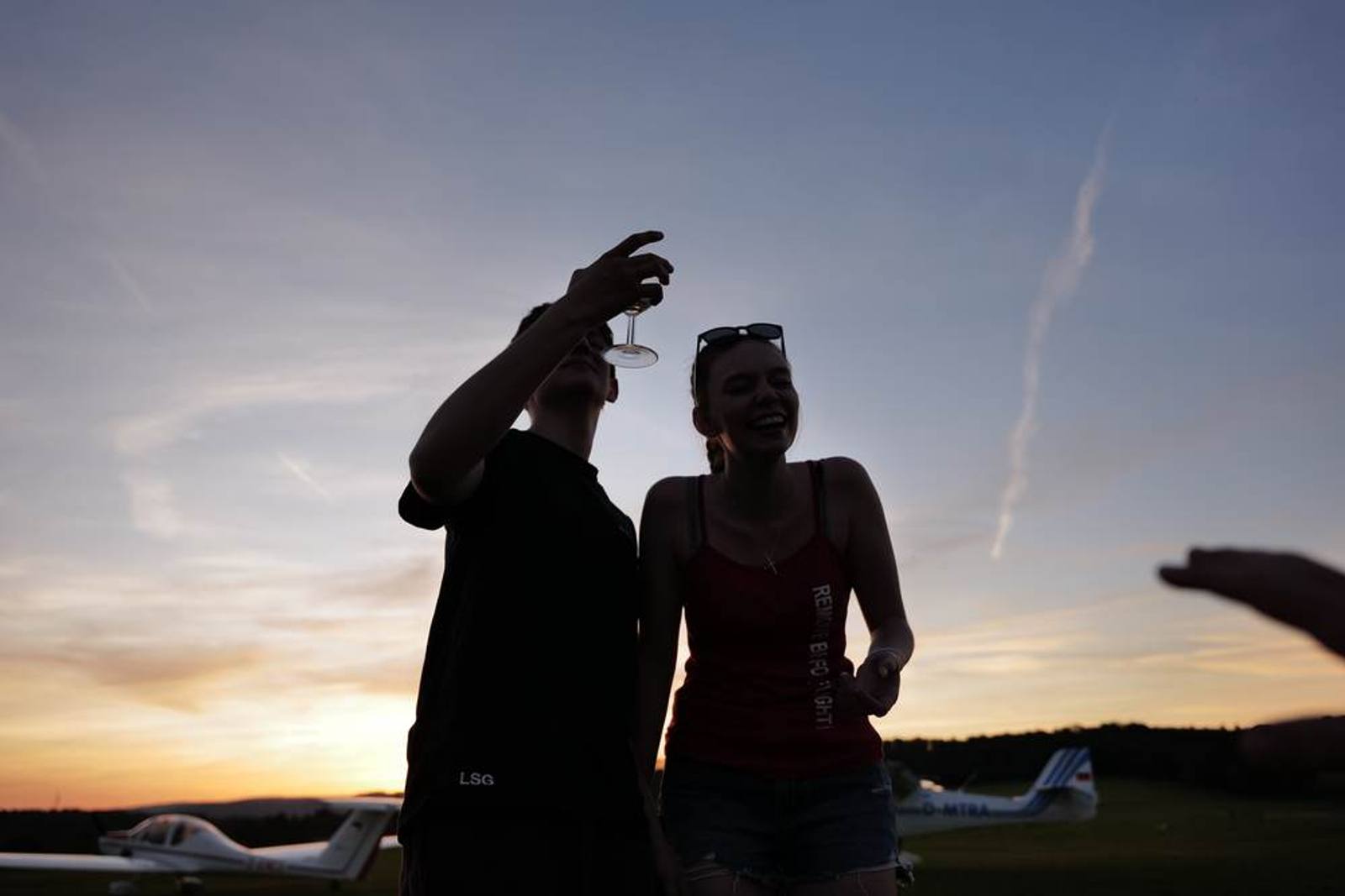 Zwei Personen als Silhouetten vor dem Abendhimmel