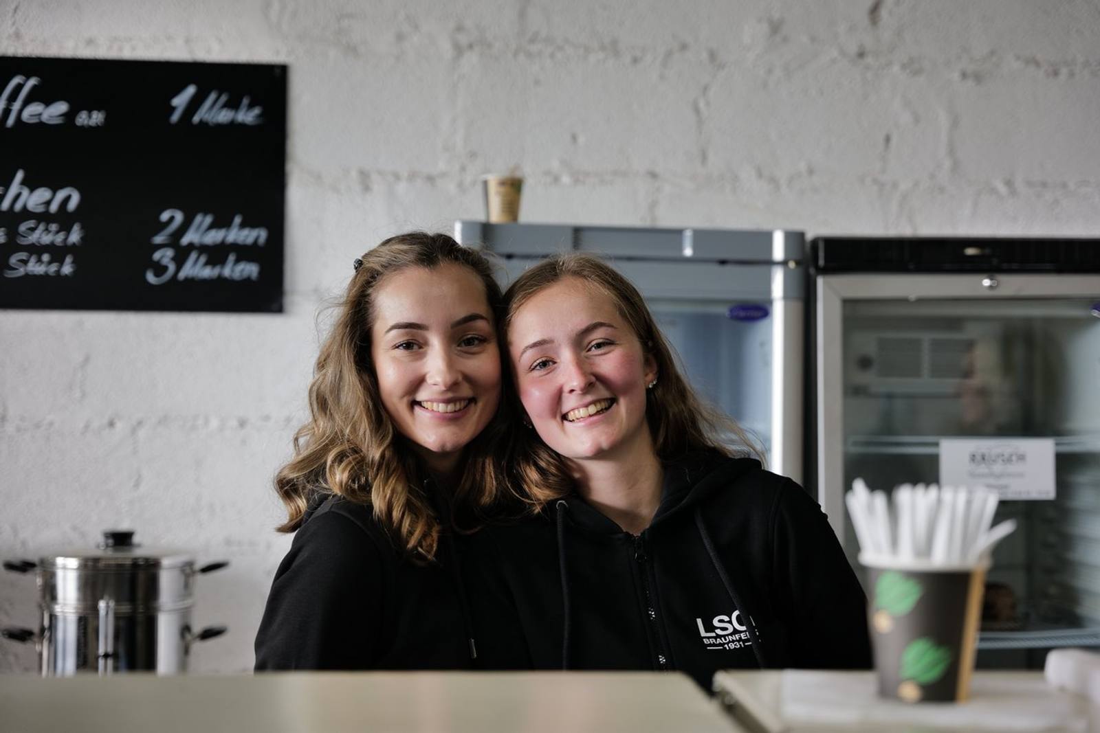 Zwei Mitglieder hinter der Kuchentheke — zur Galerie