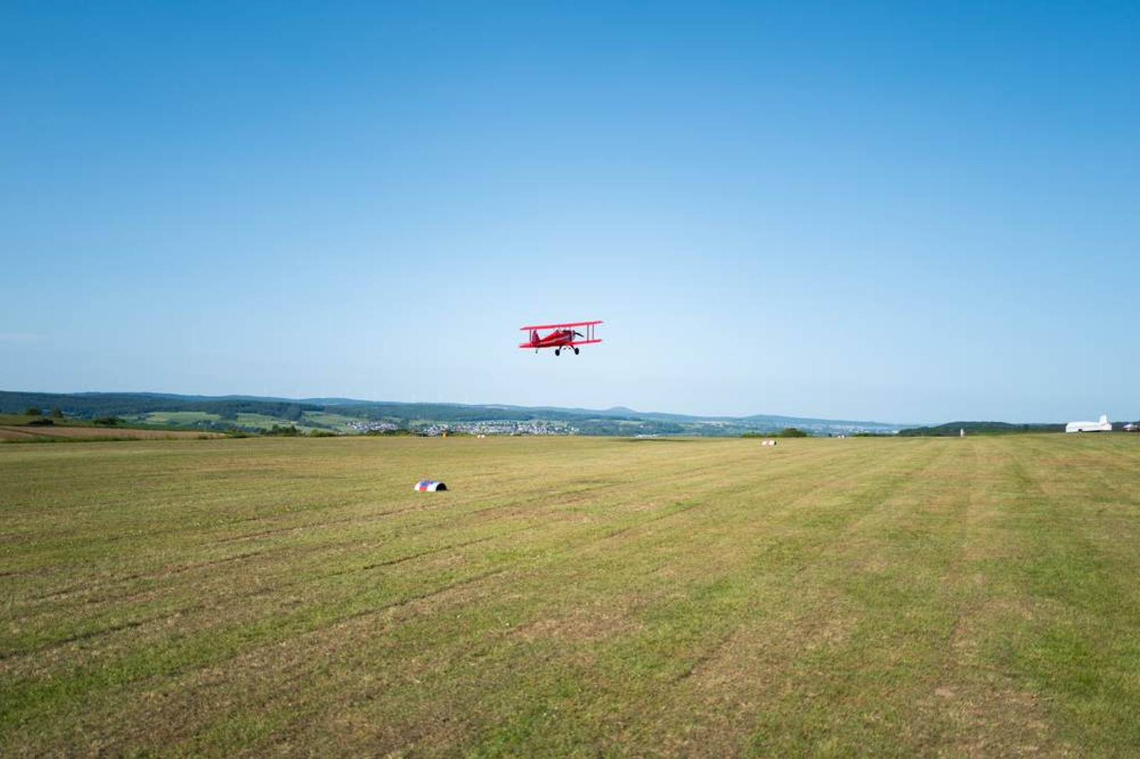 Rotes Flugmodell über dem Platz