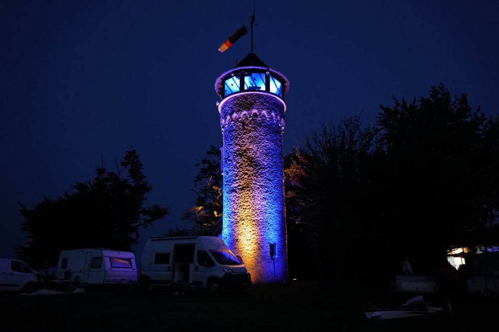 Angestrahlter Turm am Abend über dem Flugplatz
