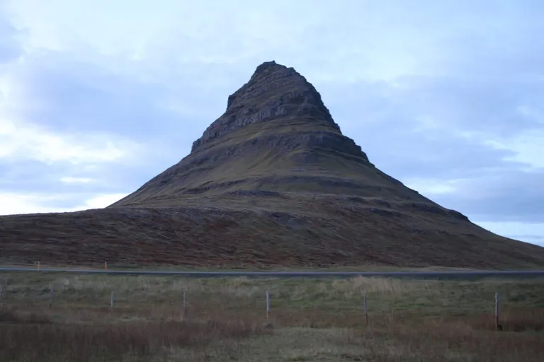 Kirkjufell mountain beneath an overcast sky.