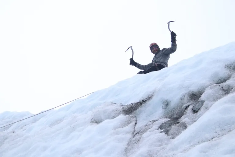 Alfred holding two ice axes during his guided glacier hike in Iceland.