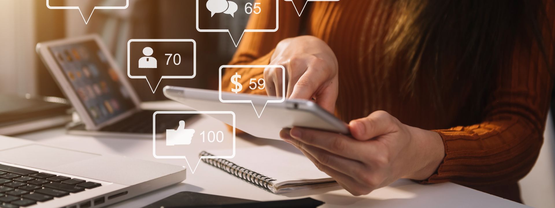 A person is using a tablet and laptop, surrounded by floating social media icons indicating engagement metrics like likes, followers, comments, and sales, representing social media consultancy and strategy.
