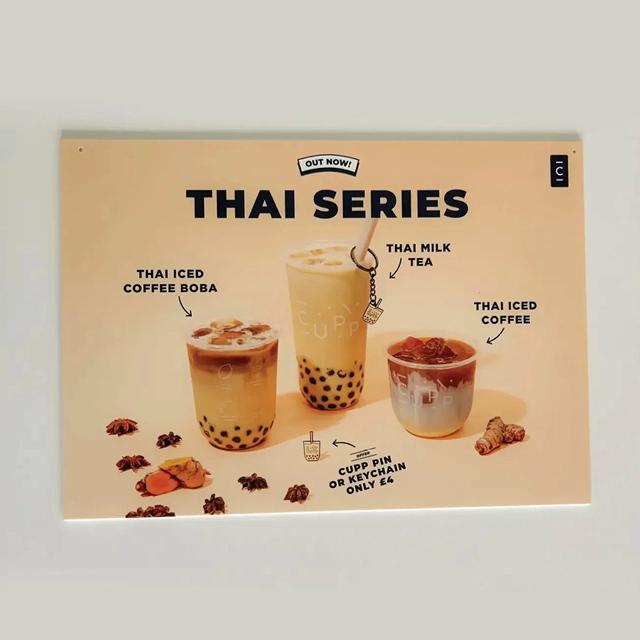 Black branded text, featuring ice beverages, on cream poster. 