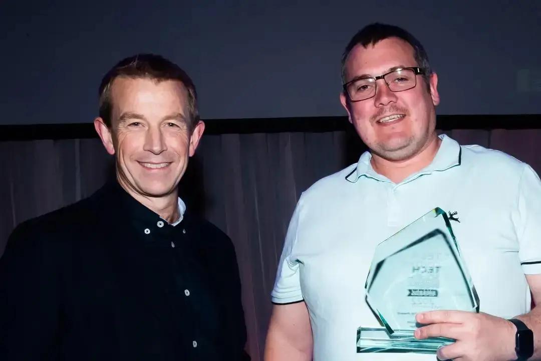 Paul Benson of Adopstar, winner of the Tech Leadership Award at the Tech South West Awards 2022, holding his clear glass trophy.