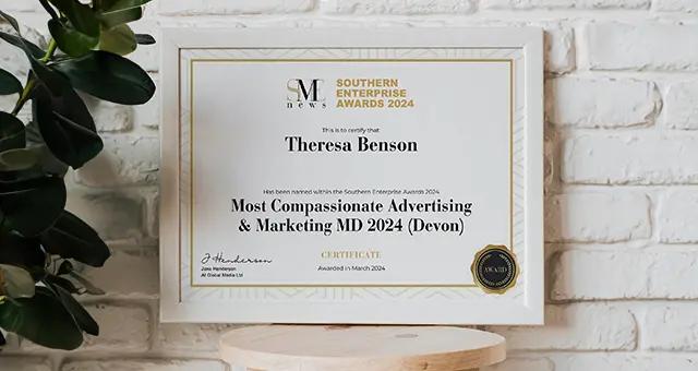 Southern Enterprise Awards 2024 certificate for Theresa Benson, Most Compassionate Advertising & Marketing MD 2024 (Devon) in a frame on a wall.