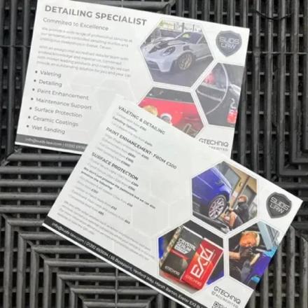 Two flyers for "SUDS LAW DETAILING SPECIALIST" are displayed. The top flyer describes their services with images of cars, while the bottom flyer details pricing for valeting, paint enhancement, and surface protection, also featuring product images and contact information.