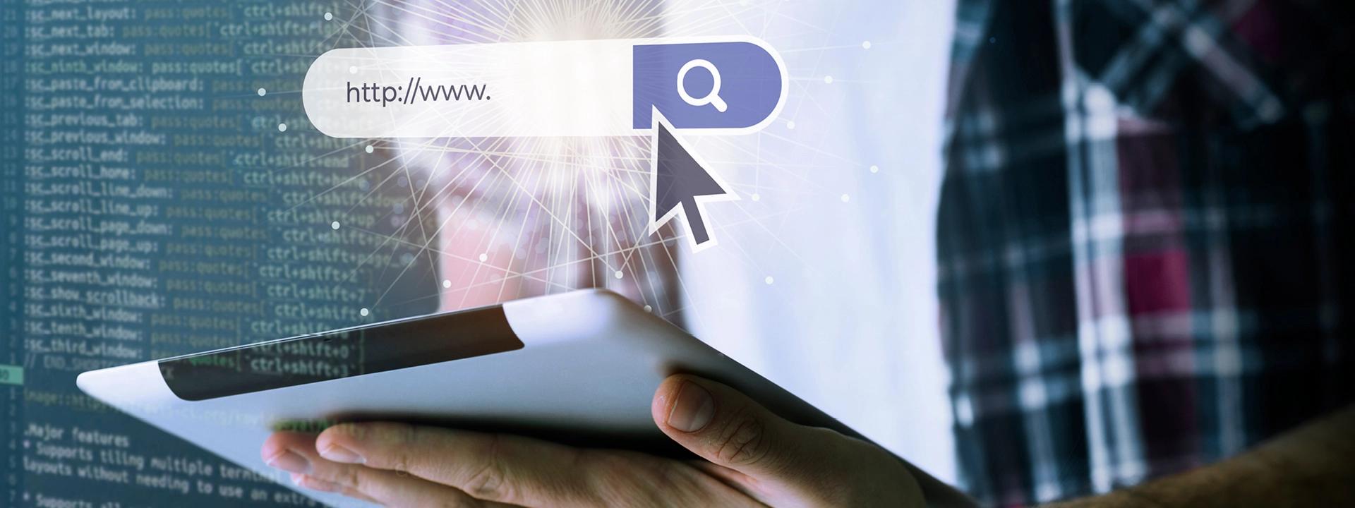 A hand holds a tablet displaying a glowing search bar with "http://www." and a search icon, with a computer cursor pointing to it, against a background of code, representing a custom web application.