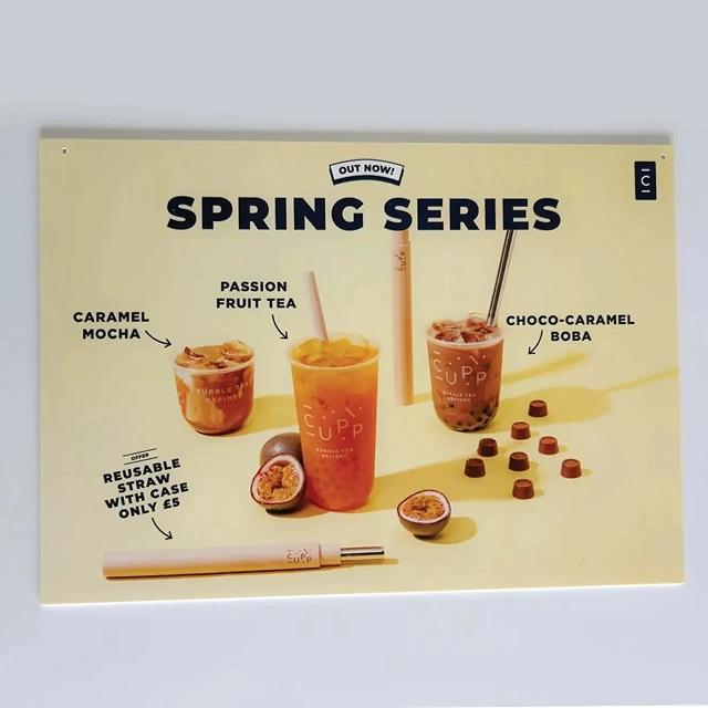 Black branded text, featuring ice beverages, on cream poster. 