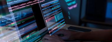  A person's hands are seen typing on a laptop keyboard, while lines of programming code and data streams are projected onto and around the screen, illustrating programmatic operations.