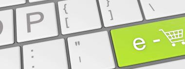 A close-up of a computer keyboard with a prominent green key featuring 'e-' and a shopping cart icon, symbolising PPC advertising specifically for e-commerce.