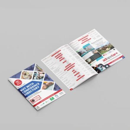  A "BUY WITH CONFIDENCE DIRECTORY" for 2023, featuring a blue, white, and red cover with images, is displayed alongside an open spread showing listings and an "Adopstar" advertisement.