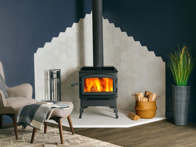 A modern wood-burning stove with a fire burning inside.