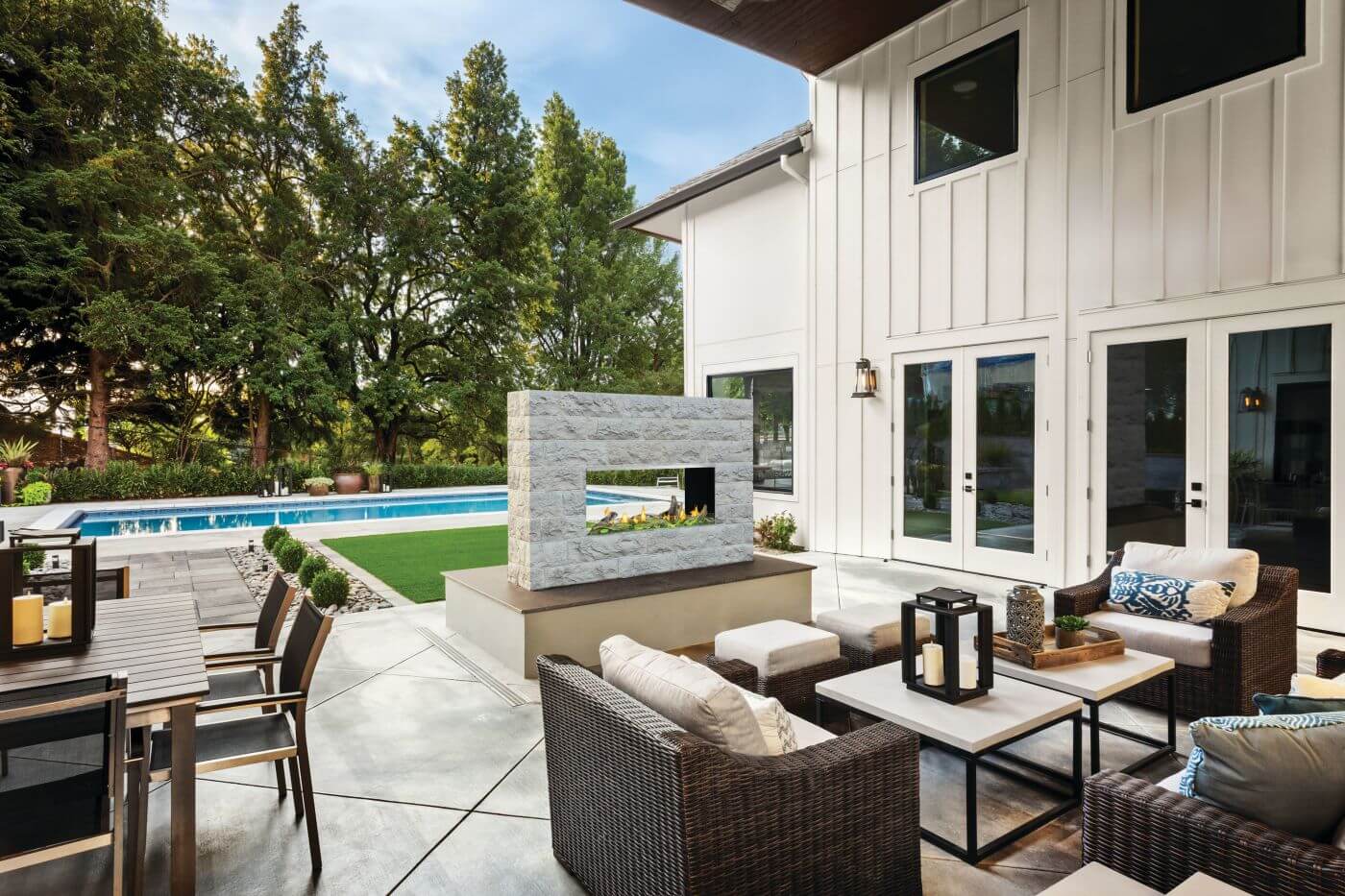 Modern patio with pool, Napoleon outdoor fireplace, and outdoor seating area.