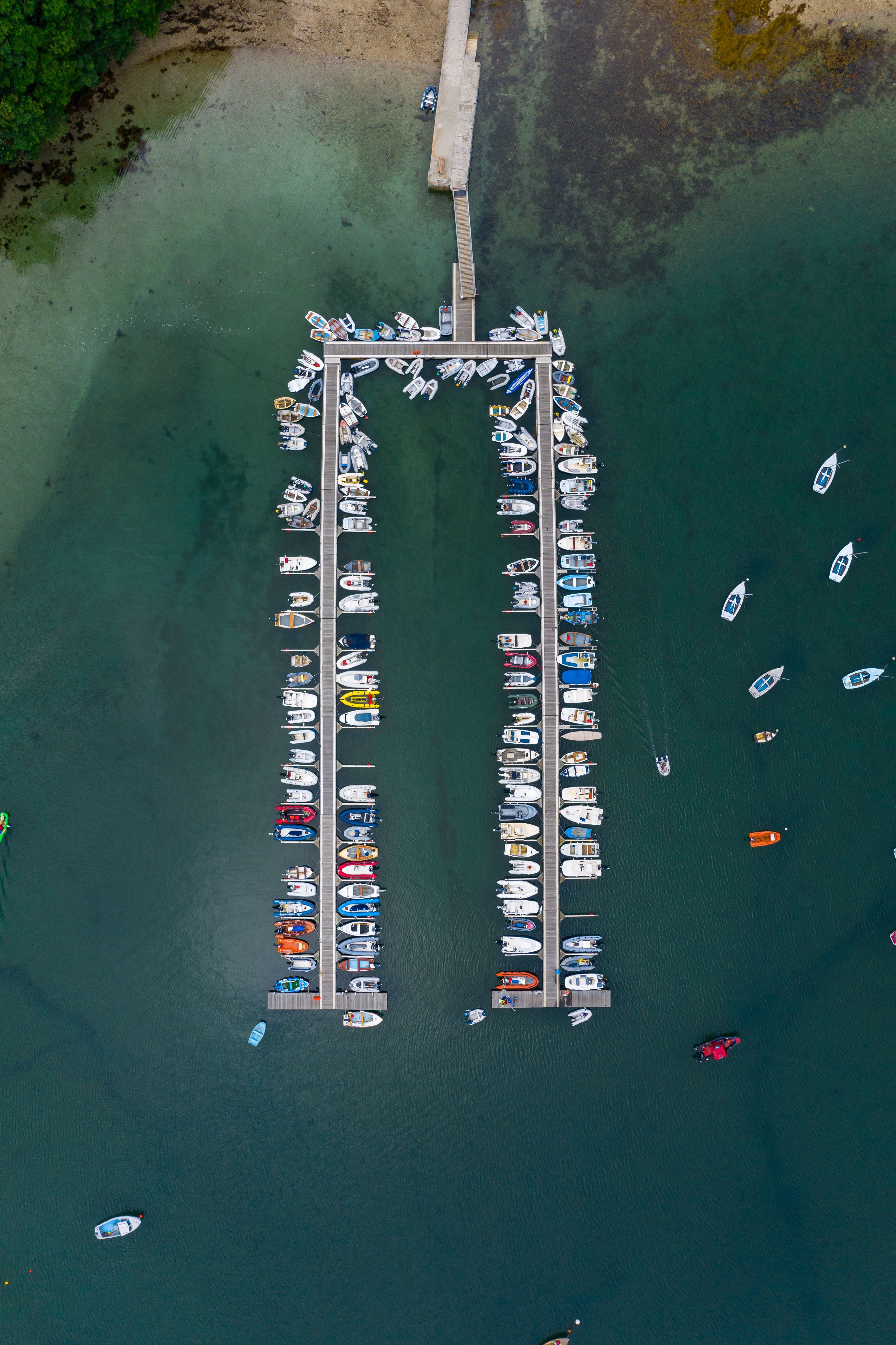 An aerial view of a pontoon with boats tied off it in Cornwall