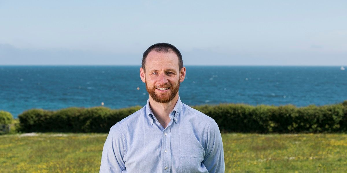 Philip Feast stands in front of a view out to sea in Falmouth, Cornwall