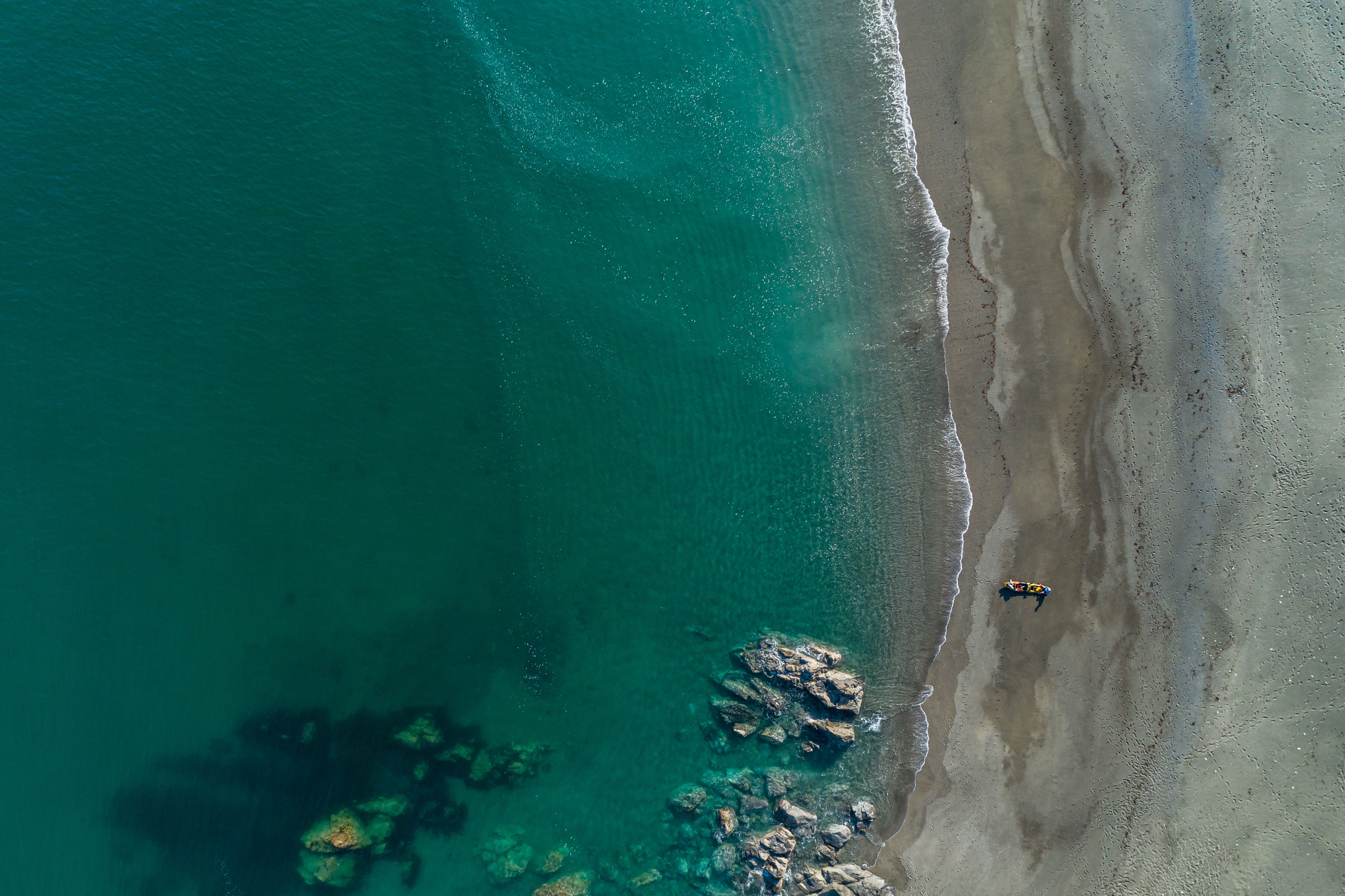 An aerial view of the beach and sea at Godrevy, Cornwall with a kayak on the beach