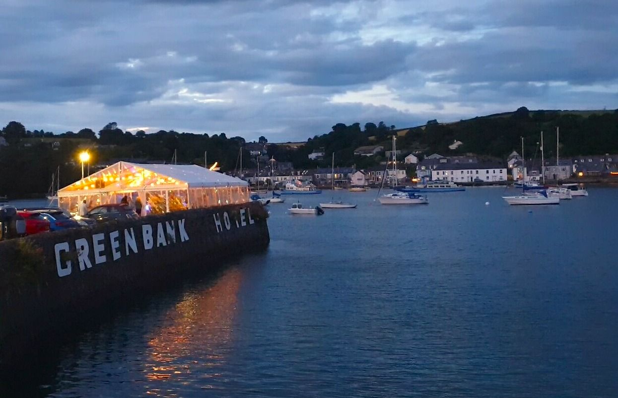 A photo at sunset of the quay at the Greenbank hotel with marquee and lights.