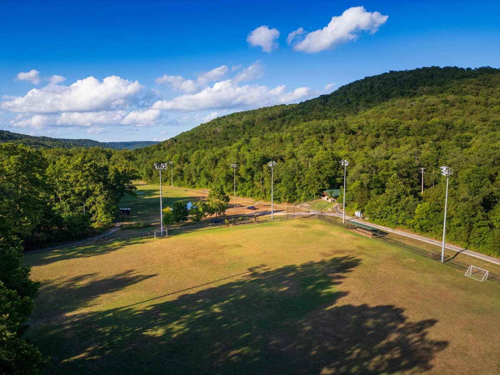Aerial view of the ballfields at Lake Leatherwood City Park, surrounded by wooded hills