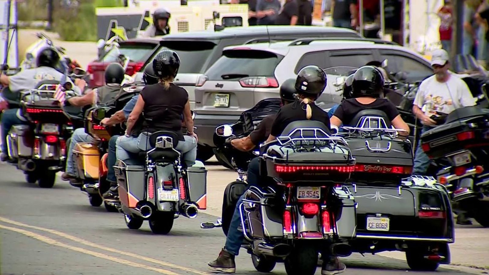 Riders on touring motorcycles moving down a street during the rally