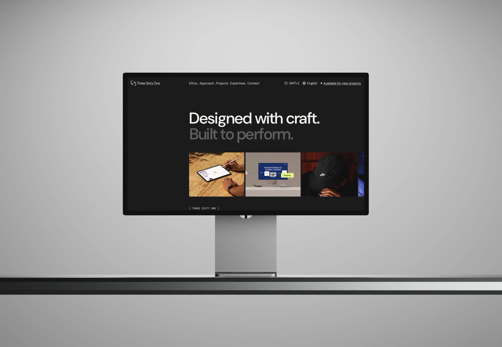 A computer monitor displays a dark website featuring the text 'Designed with craft. Built to perform.' and three small images.