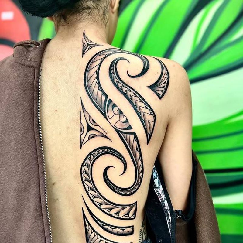 Tribal blackwork tattoo covering full back with bold abstract design