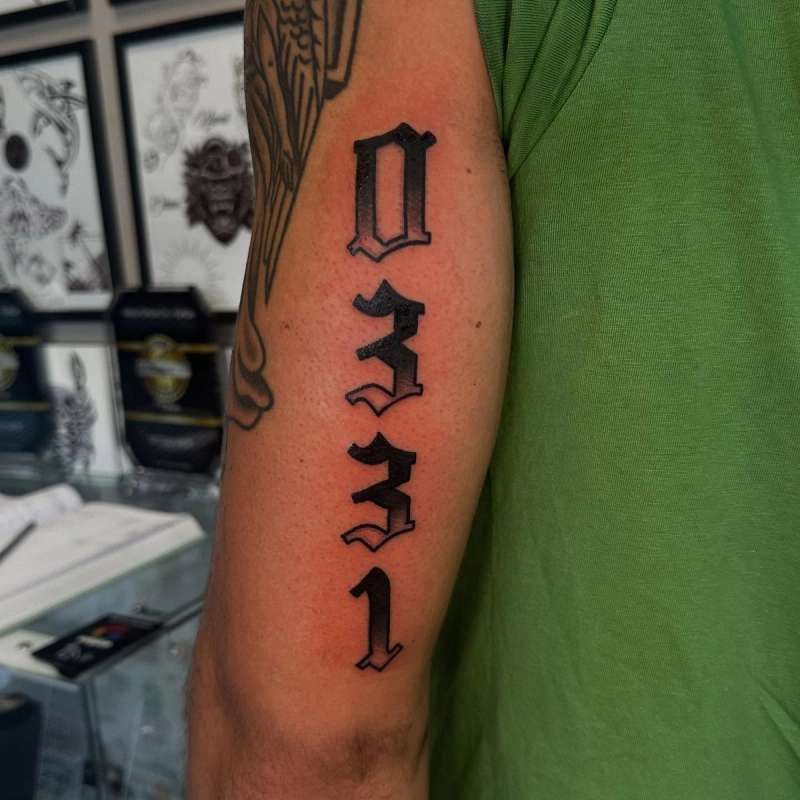 lettering tattoo on upper arm with numbers
