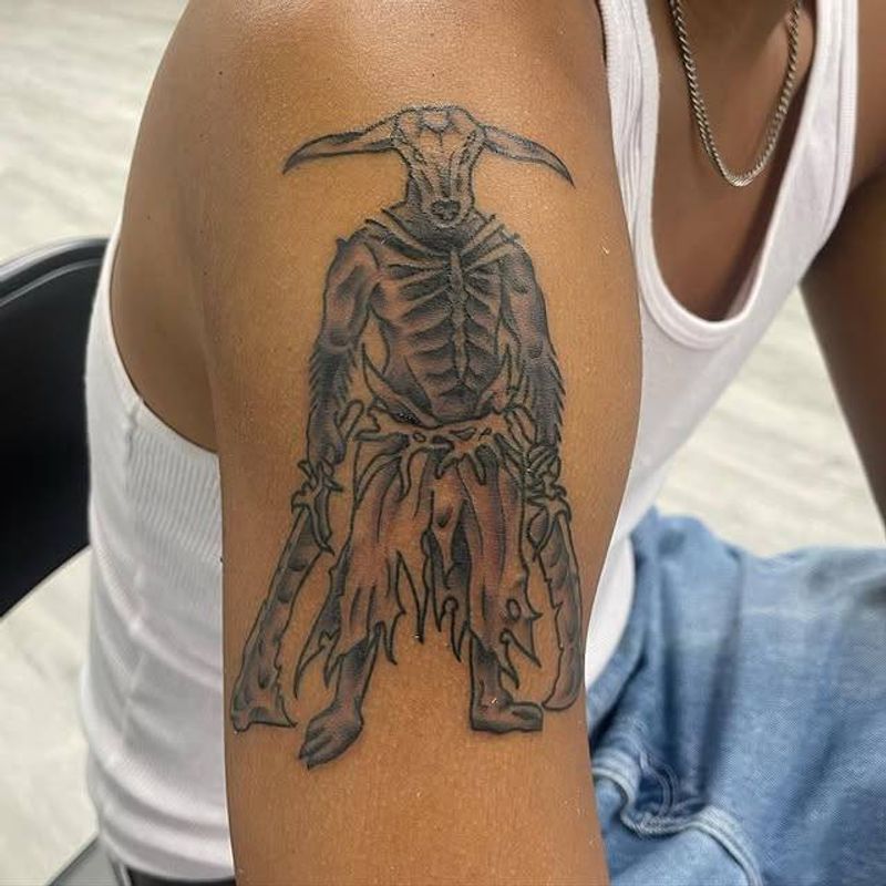 Black and grey illustrative mythical creature tattoo on upper arm