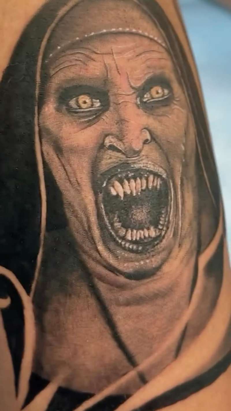 Black and grey realistic screaming face tattoo on upper arm