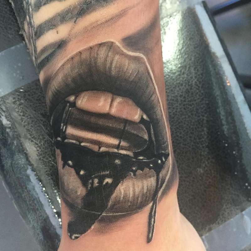 Black and grey realistic open mouth tattoo on forearm