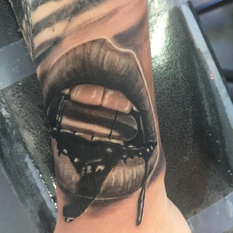 Black and grey realistic open mouth tattoo on forearm