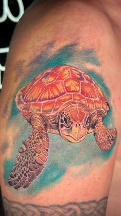 colorful sea turtle tattoo on upper arm