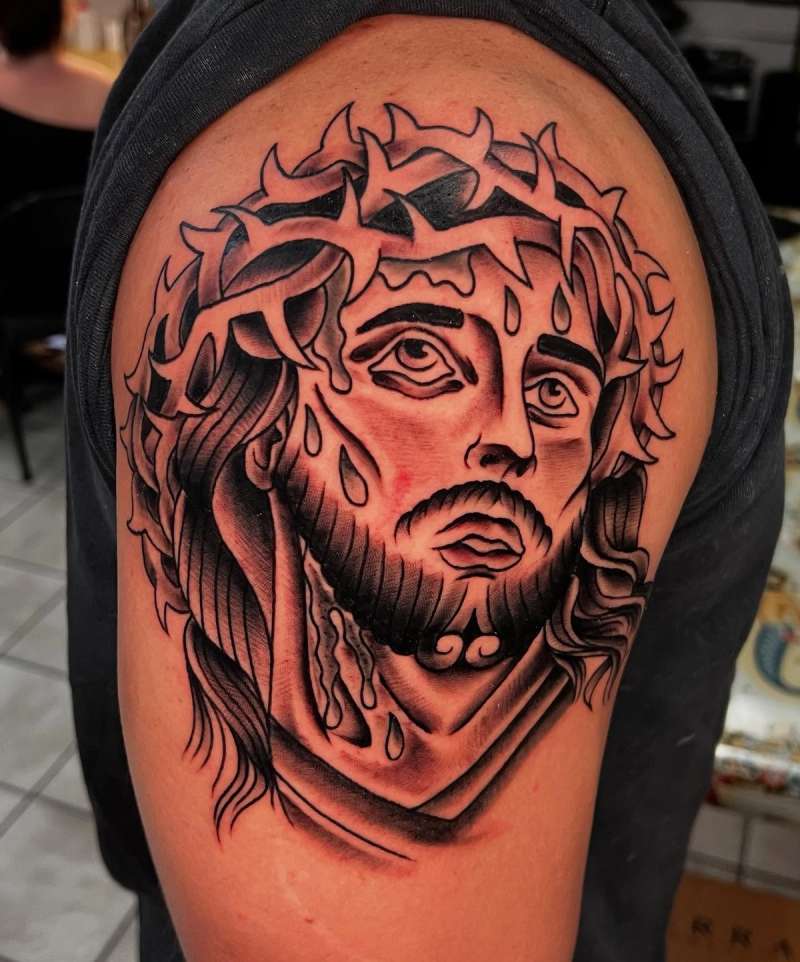Black and grey illustrative tattoo of Jesus with a crown of thorns on upper arm