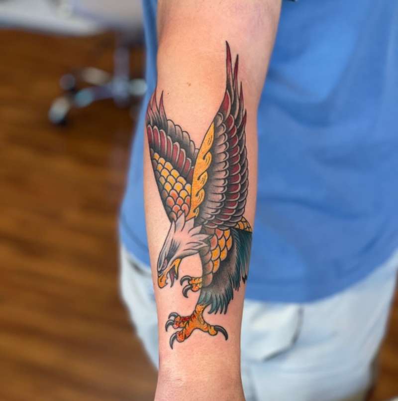 Colorful traditional eagle tattoo on forearm