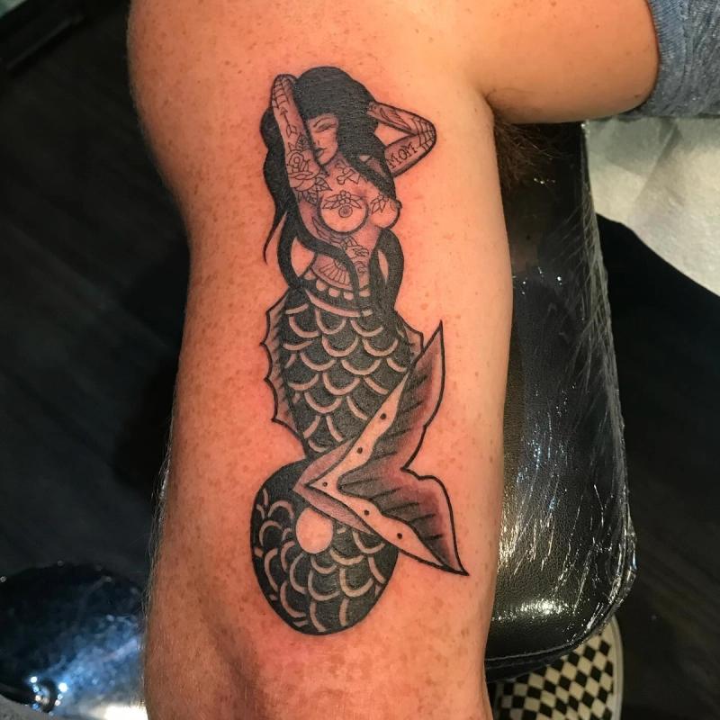 blackwork mermaid tattoo on upper arm