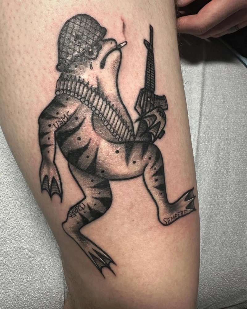 Black and grey illustrative frog in military gear on thigh