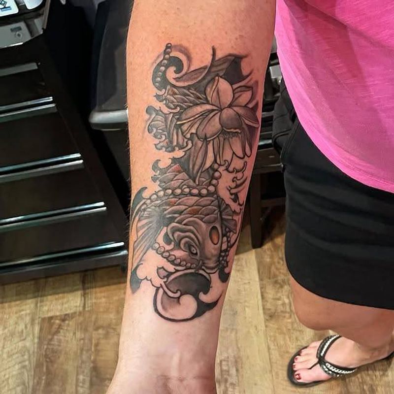 Black and grey koi fish tattoo on forearm