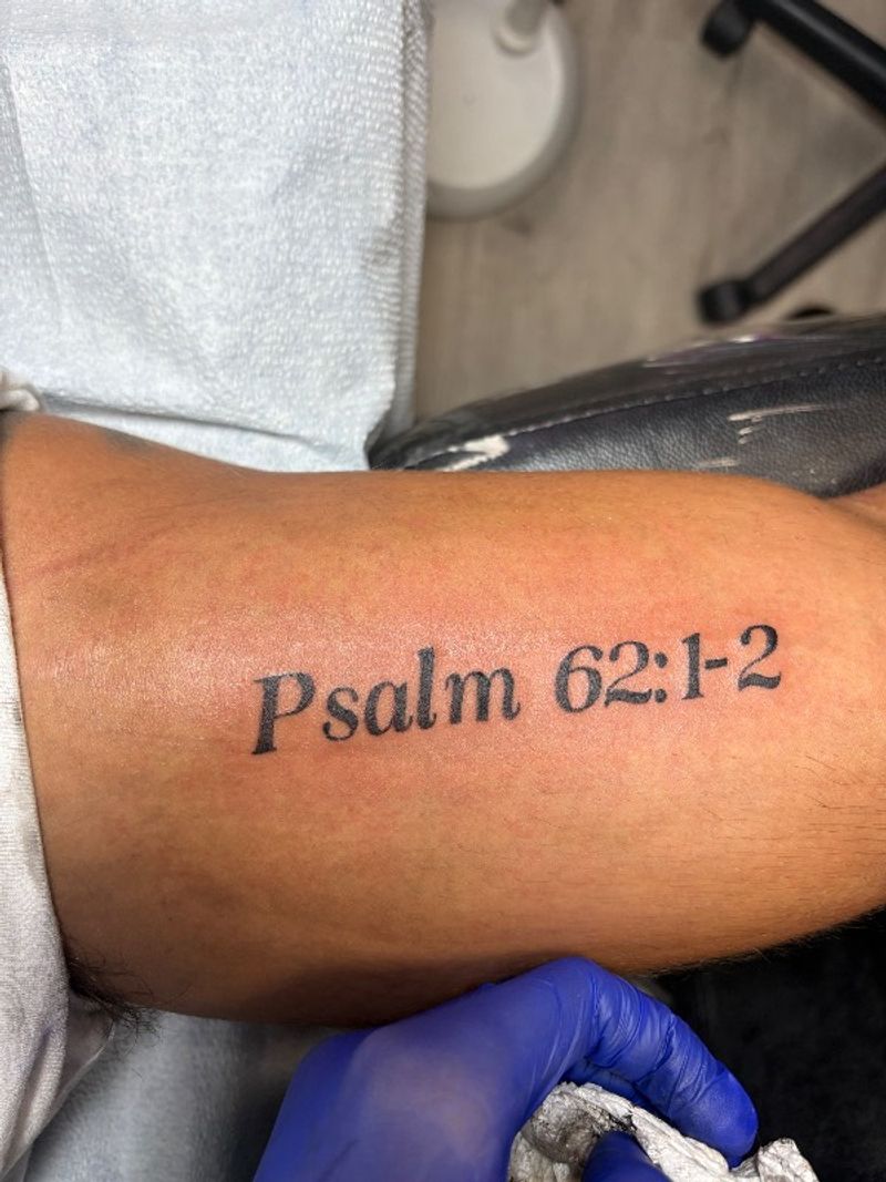 black lettering tattoo of psalm verse on upper arm