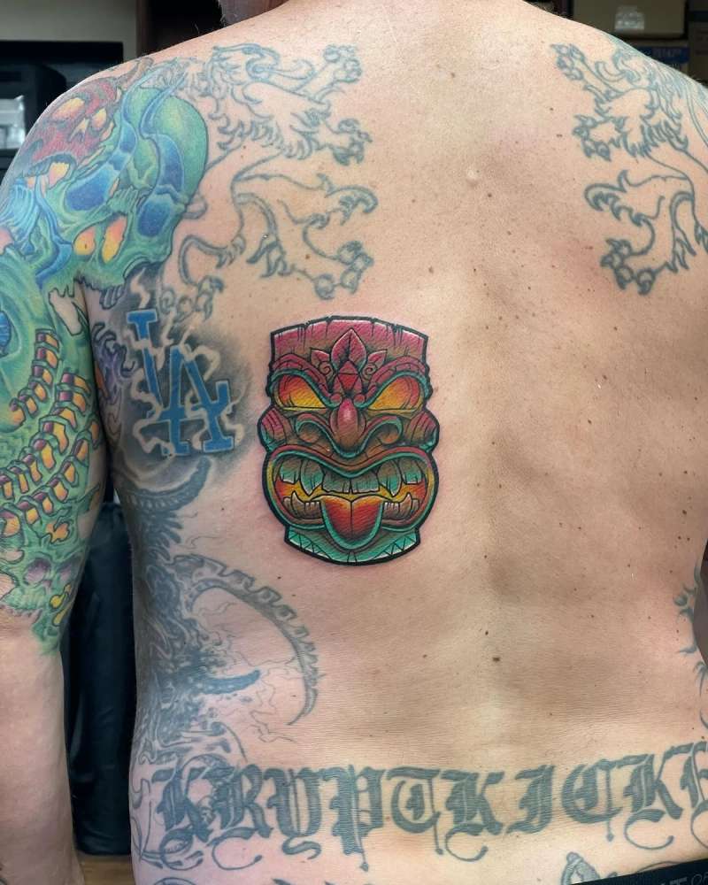 colorful tiki mask tattoo on upper back