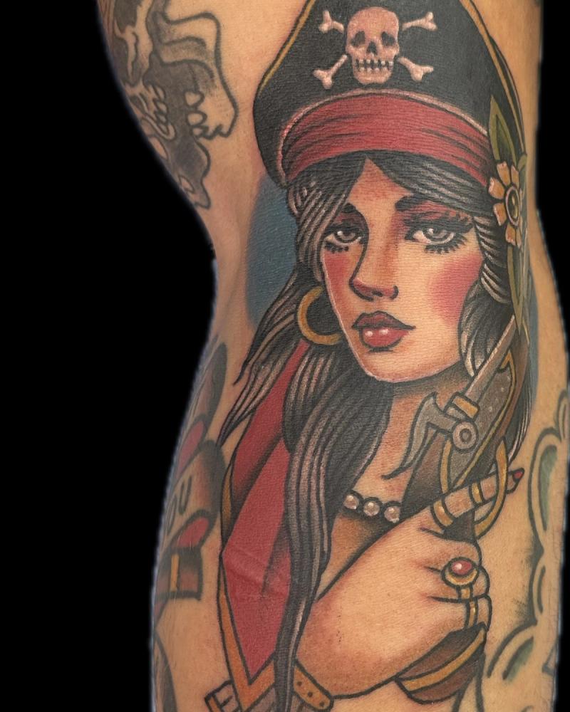 Colorful neo traditional pirate woman tattoo on upper arm