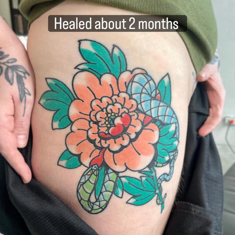 healed japanese style peony and snake tattoo on upper arm