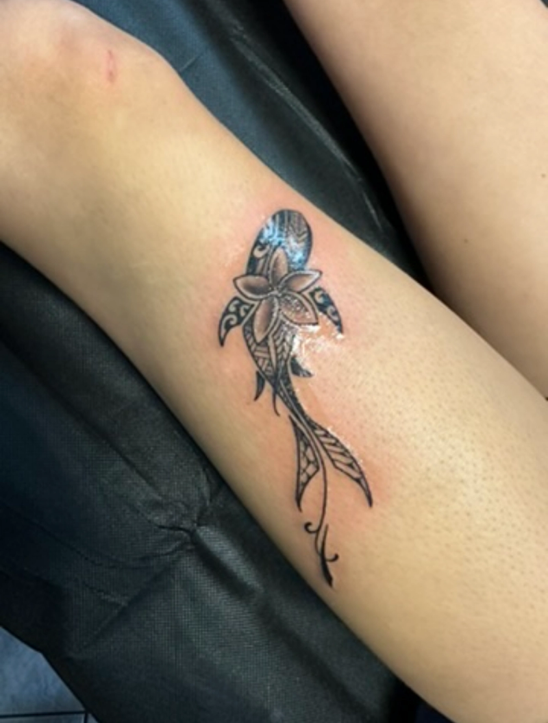 Black and grey tribal flower tattoo on calf